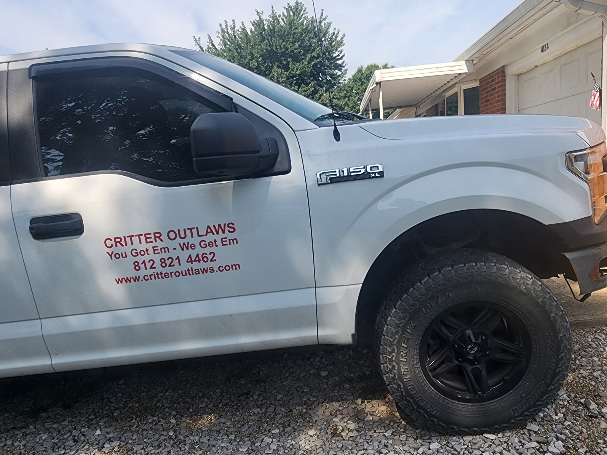 Critter Outlaws wildlife removal service truck with company logo and phone number